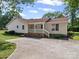 Side view of home showcasing the large driveway and covered porch with white railings at 1302 Hawthorne Rd, Lancaster, SC 29720