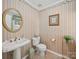 Charming half bathroom featuring a pedestal sink, decorative wallpaper, and elegant fixtures at 1302 Hawthorne Rd, Lancaster, SC 29720