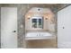 Bathroom featuring a soaking tub under a window, decorative tile, and white doors at 135 Primrose Dr, Salisbury, NC 28147