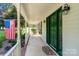 Inviting front porch with a vibrant green door, 'Welcome' mat, and American flag at 135 Primrose Dr, Salisbury, NC 28147