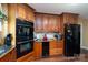 Kitchen boasts wooden cabinets, built-in oven, and stainless-steel refrigerator at 135 Primrose Dr, Salisbury, NC 28147