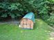 An outbuilding with a green roof nestled among mature trees in the backyard at 135 Primrose Dr, Salisbury, NC 28147