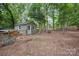 Wooded backyard featuring a shed, hammock, and fenced enclosure, offering privacy and outdoor space at 140 Quiet Cove Rd, Mooresville, NC 28117