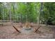 Enjoy outdoor evenings around this stone fire pit surrounded by wooden chairs and lush greenery at 140 Quiet Cove Rd, Mooresville, NC 28117
