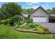 Charming gray home featuring a well-manicured lawn, mature landscaping, and an attached two-car garage at 140 Quiet Cove Rd, Mooresville, NC 28117