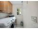 Functional laundry room featuring a modern washer and dryer set, cabinet space, and a window at 140 Quiet Cove Rd, Mooresville, NC 28117