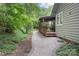 A shaded patio extends from the home, connected by a stone path and lush green foliage at 140 Quiet Cove Rd, Mooresville, NC 28117