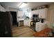 Bright kitchen featuring stainless appliances, white cabinets, and wood-look flooring at 148 W Walnut Ave, Mount Holly, NC 28120
