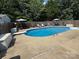 Inviting backyard pool with diving board, surrounded by a concrete patio and privacy fence at 148 W Walnut Ave, Mount Holly, NC 28120