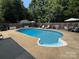 Inviting backyard pool with diving board, surrounded by a concrete patio and privacy fence at 148 W Walnut Ave, Mount Holly, NC 28120