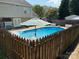 Inviting backyard pool with diving board, surrounded by a concrete patio and privacy fence at 148 W Walnut Ave, Mount Holly, NC 28120