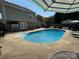 Inviting backyard pool with diving board, surrounded by a concrete patio and privacy fence at 148 W Walnut Ave, Mount Holly, NC 28120