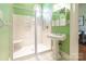 Bathroom featuring a tile shower with glass door, a unique pedestal sink, and green walls at 15 Kings Mountain St, York, SC 29745