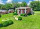 Beautiful brick home with a large front lawn, stately columns, outbuilding, and mature trees at 15 Kings Mountain St, York, SC 29745