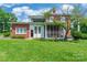 Exterior of home features well-manicured lawn, lush greenery and a screened in porch at 15 Kings Mountain St, York, SC 29745