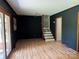 Spacious living room featuring wood floors, dark accent walls, and access to the staircase at 1909 Normandy Rd, Kannapolis, NC 28081
