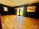 Spacious living room featuring wood floors, dark accent walls, and sliding glass door to the yard at 1909 Normandy Rd, Kannapolis, NC 28081