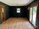 Living room with wood floors, dark accent walls, access to a window, and a sliding glass door at 1909 Normandy Rd, Kannapolis, NC 28081