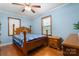 Bright bedroom featuring light blue walls, wood floors, and a large wooden bed at 1920 E Nc Hwy 24/27 None, Biscoe, NC 27209