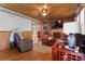 Cozy living room with wood-paneled walls, a ceiling fan, and a stone fireplace at 1920 E Nc Hwy 24/27 None, Biscoe, NC 27209