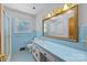 Bathroom featuring blue tile, vanity, mirror with gold frame, and natural light at 207 W 21St St, Kannapolis, NC 28081