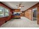 Open living area with wood-paneled walls, bright windows, updated floors, and a modern ceiling fan at 207 W 21St St, Kannapolis, NC 28081