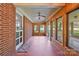 Enclosed brick porch with ceiling fan, windows and terra-cotta style flooring at 207 W 21St St, Kannapolis, NC 28081