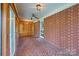 Enclosed brick porch with terra-cotta style flooring, ceiling fans, and natural light at 207 W 21St St, Kannapolis, NC 28081