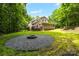 Charming backyard features a fire pit with seating area, lush greenery and a well-maintained lawn at 2156 Wedgewood Dr, Matthews, NC 28104