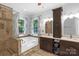 Bright bathroom featuring a tub, a glass shower and double sink vanity with storage and a neutral palette at 2156 Wedgewood Dr, Matthews, NC 28104