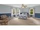 Inviting bedroom featuring light carpet, two-toned walls, windows that offer views of the greenery and a comfortable chair at 2156 Wedgewood Dr, Matthews, NC 28104
