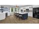 Modern kitchen featuring a large island with seating, white cabinets, stainless appliances, and hardwood floors at 2156 Wedgewood Dr, Matthews, NC 28104