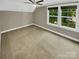 Upstairs bedroom with ceiling fan, carpet, large window and neutral paint at 2222 Camp Greene St, Charlotte, NC 28208