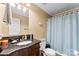 Bathroom with granite counters, wooden vanity, and shower with light blue curtain at 223 Green Meadows Dr, Kings Mountain, NC 28086