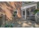 This covered back porch features brick walls, wrought iron table and chairs, and views of the screened porch at 2358 Sparrow Dr, Rock Hill, SC 29732