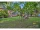 The lush backyard features mature trees, a playset, and glimpses of the brick home's back porch and screened porch at 2358 Sparrow Dr, Rock Hill, SC 29732