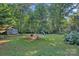 Spacious backyard featuring mature trees, a storage shed, a playground, and a fire pit at 2358 Sparrow Dr, Rock Hill, SC 29732