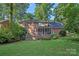 The brick home features a screened porch, back deck with stairs, and lush backyard with mature trees and plants at 2358 Sparrow Dr, Rock Hill, SC 29732