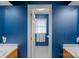 Well-lit bathroom has a hexagon-tiled floor, bright blue walls, and a small window with curtains at 2358 Sparrow Dr, Rock Hill, SC 29732