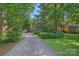 View of the driveway leading to a traditional brick home surrounded by mature trees at 2358 Sparrow Dr, Rock Hill, SC 29732