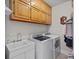 Laundry room featuring washer, dryer, sink, wooden cabinets, and tiled floor at 2358 Sparrow Dr, Rock Hill, SC 29732