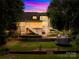 Beautiful backyard at dusk featuring a tiered design, manicured lawn, and elegant string lights at 2455 Talbot Ct, Sherrills Ford, NC 28673
