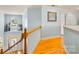 Bright hallway with wood floors, white trim, and staircase leading to entry door at 2455 Talbot Ct, Sherrills Ford, NC 28673