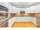 Modern kitchen featuring white cabinets, granite countertops, stainless steel appliances, and hardwood floors at 2455 Talbot Ct, Sherrills Ford, NC 28673
