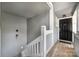 Unit 23 entrance featuring a black door, gray siding, and wood stairs at 2510 Cranbrook Ln, Charlotte, NC 28207