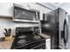Kitchen featuring stainless steel microwave, black cooktop stove and granite countertops at 2510 Cranbrook Ln, Charlotte, NC 28207