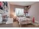 Pink bedroom featuring a bed with decorative pillows, window, and vanity at 2936 Saintfield Pl, Charlotte, NC 28270