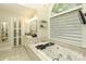 Bright bathroom boasting a soaking tub, marble countertop, and natural light from a large window at 3015 Rochester Ct, Monroe, NC 28110