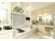 Elegant bathroom featuring a soaking tub, marble accents, and natural light from a large window at 3015 Rochester Ct, Monroe, NC 28110