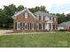 A traditional two-story brick home features a manicured lawn and symmetrical design at 3015 Rochester Ct, Monroe, NC 28110